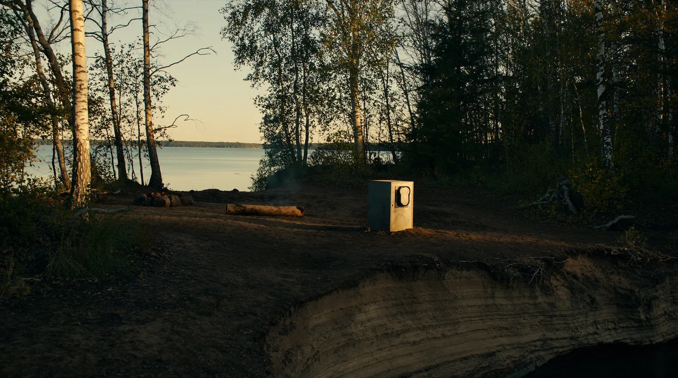 A quiet island campsite in mixed birch and spruce forest with a fire ring, a picnic table and a metal bear-proof food locker, cold Lake Superior water visible through the trees, Apostle Islands Wisconsin, ultrarealistic photograph representative of the region