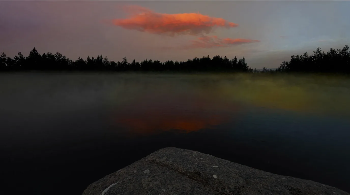 A wilderness lake at dusk in northern Minnesota with still dark water reflecting the last light, black spruce silhouetted along a low granite shoreline and no sign of human presence, ultrarealistic photograph representative of the region