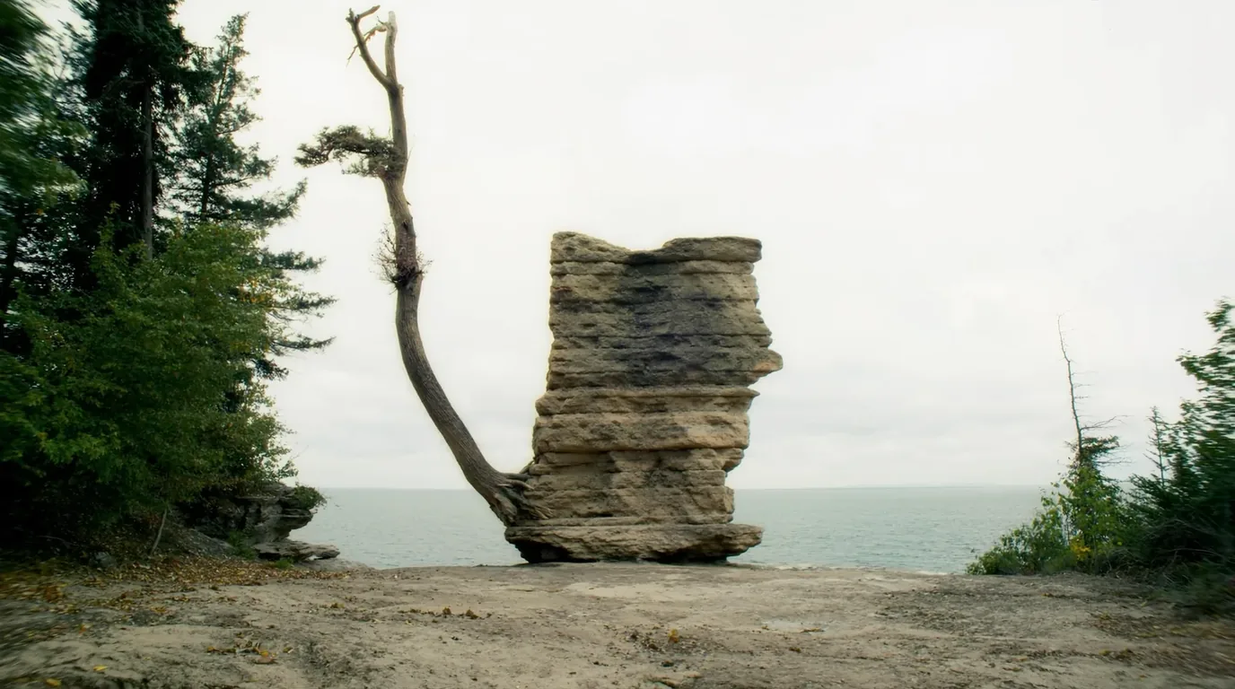 A turreted sandstone promontory standing out over Lake Superior with turquoise shallows and deep blue water beyond, layered rock and conifers on top, Miners Castle Pictured Rocks Michigan, ultrarealistic photograph representative of the region